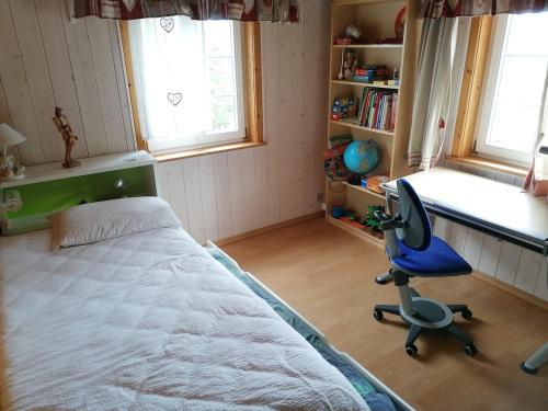 a bedroom with a bed and a desk and a chair at Family chalet appartment 150 qm at Lake Zurich in Altendorf