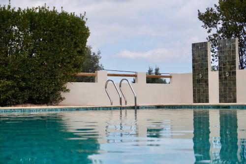 a swimming pool with two metal swimmers in the water at Hotel Finca Olivar in Benissa