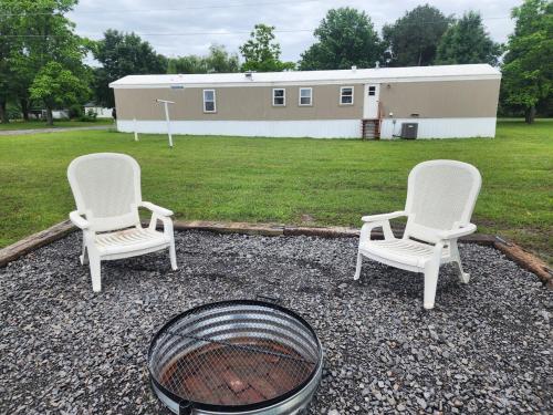 two chairs and a fire pit in front of a building at Pop's Place -Lakeview 3bd 2 ba on 6 acres in Fort Gibson
