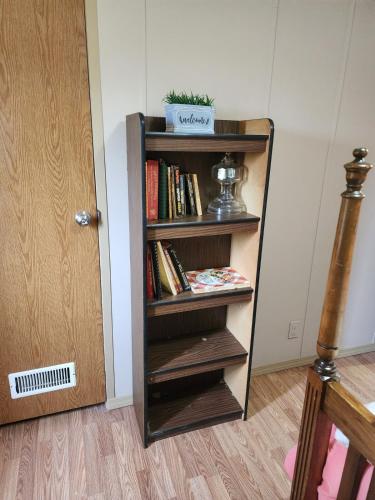 a book shelf filled with books next to a door at Pop's Place -Lakeview 3bd 2 ba on 6 acres in Fort Gibson