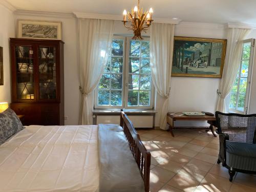 a bedroom with a large bed and two windows at Inge's Arthouse bei Frankfurt in Eschborn
