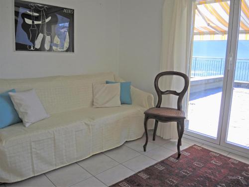 a living room with a couch and a chair and a window at Casa Lucciola by Fewotessin in Contra