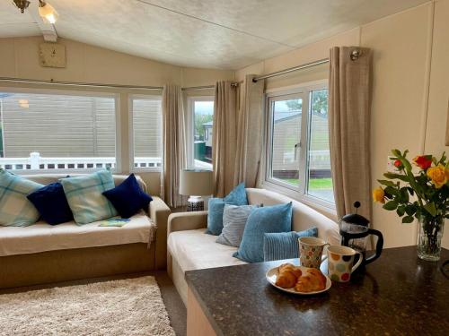 a living room with a couch and a table at Seascape at Landscove Holiday Park, Brixham in Brixham