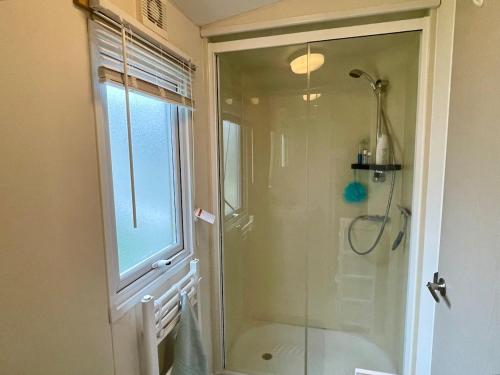 a bathroom with a shower with a glass door at Seascape at Landscove Holiday Park, Brixham in Brixham