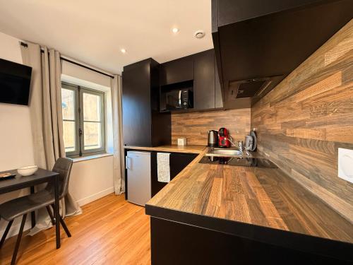 une cuisine avec des armoires noires et un comptoir dans l'établissement Le Baroque Studio Wifi, à Narbonne