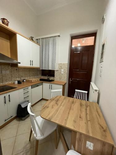 a kitchen with a wooden table and white cabinets at Varvayanni Villa in Plomarion