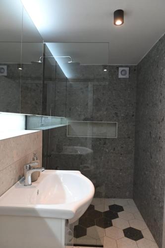 a bathroom with a sink and a glass shower at Forest Heaven Retreat with jakuzz in Čačak