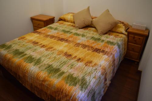 a bedroom with a bed with a colorful comforter at Benissanet Tarragona Apartment Cal Sanet in Benissanet
