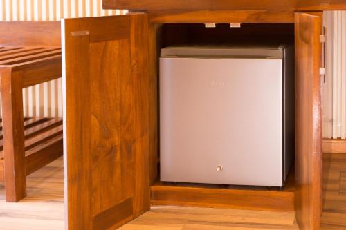 a television sitting inside of a wooden cabinet at Hotel Grand Turf By GSP in Nuwara Eliya