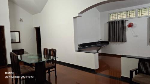 a dining room with a glass table and a sink at Stone Villa in Blooms Green Farm in Wayanad