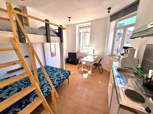 Cette petite chambre comprend des lits superposés et un bureau. dans l'établissement Charmant Studio 3 pers - Hyper centre d'Arras, à Arras