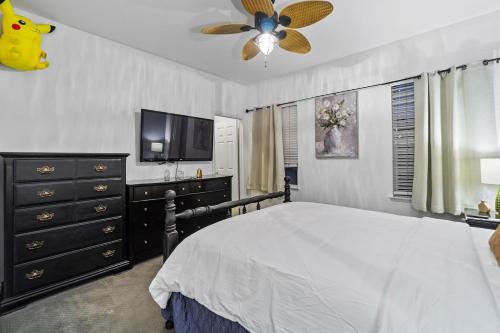 a bedroom with a bed with a ceiling fan and a tv at Entire Private 5-BR Villa w Pool, Spa, Nature, 3000 sq ft, Private Rental, Available Now in Fallbrook