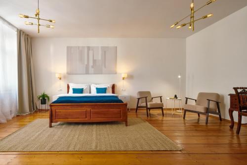 a bedroom with a bed and two chairs and a table at Latran House 71 by KH in Český Krumlov