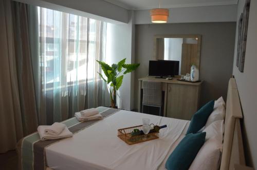 a bedroom with a bed with a tray on it at Aqua Mare Sea Side Rooms in Nea Kalikratia