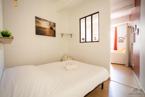 a bedroom with a white bed and a window at Le Carignan - 4 personnes - Proche des plages in Lapalme