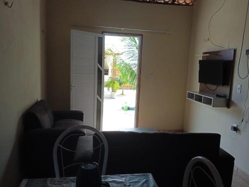 a living room with a couch and a sliding glass door at Condominio Nina2 in Icapuí