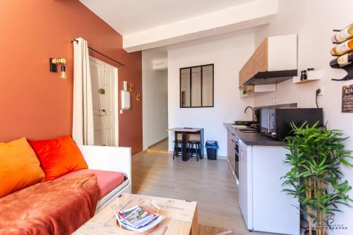 un salon avec un canapé et une cuisine dans l'établissement Le Carignan - 4 personnes - Proche des plages, à Lapalme