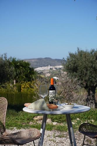 a table with a bottle of wine and food on it at Hotel Finca Olivar in Benissa