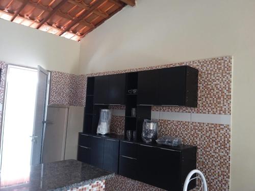 a kitchen with black cabinets and a black counter top at Condominio Nina2 in Icapuí