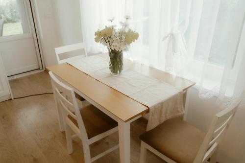 a vase of flowers sitting on a table with two chairs at Casa Abiiani in Oradea