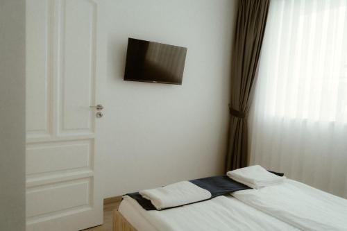 a room with a bed with a television on the wall at Casa Abiiani in Oradea