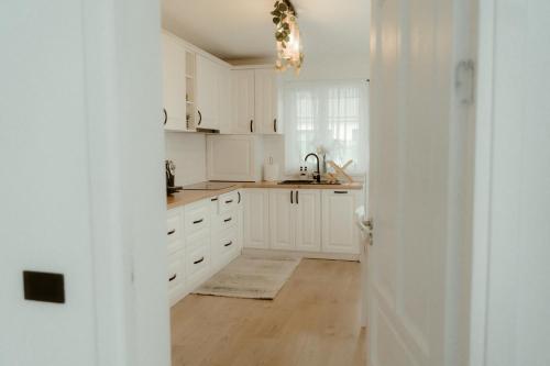 a white kitchen with white cabinets and a sink at Casa Abiiani in Oradea