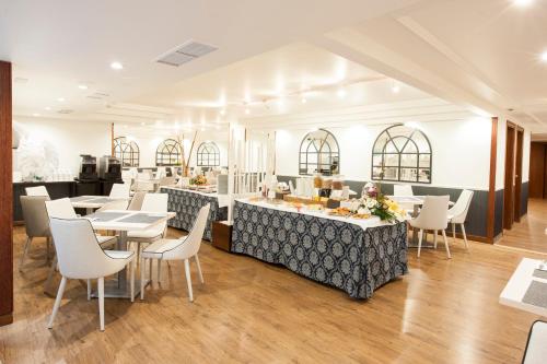 a restaurant with tables and chairs and a counter at Hotel Gran Via in Logroño