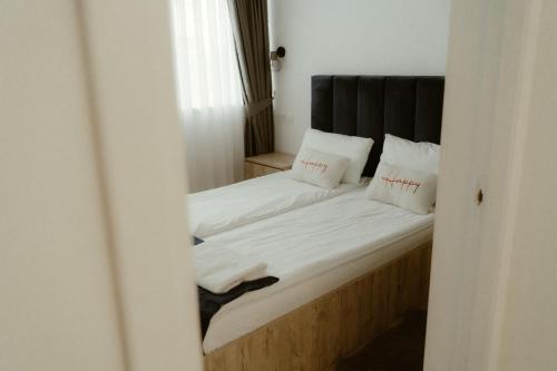 a bedroom with a bed with white sheets and pillows at Casa Abiiani in Oradea