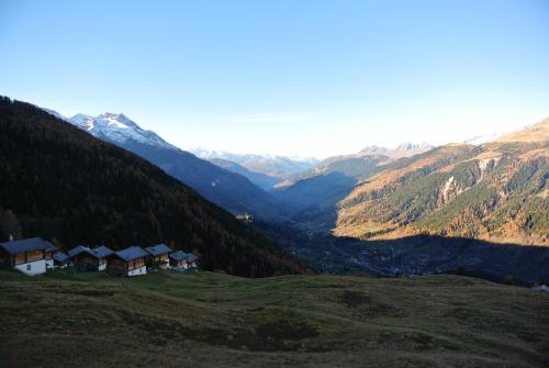 a view of a valley with houses and mountains at Berghotel Chäserstatt in Ernen