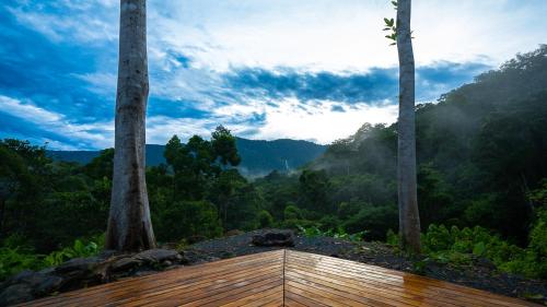 a wooden deck with a view of a forest at QASA Hotel and Retreat Center in San Luis