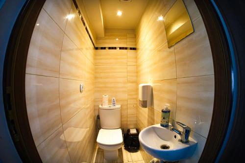 a small bathroom with a toilet and a sink at Sunny Hostel 49 in Wrocław