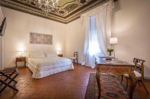 a bedroom with a bed and a table and a window at Dimora Bandinelli in Florence