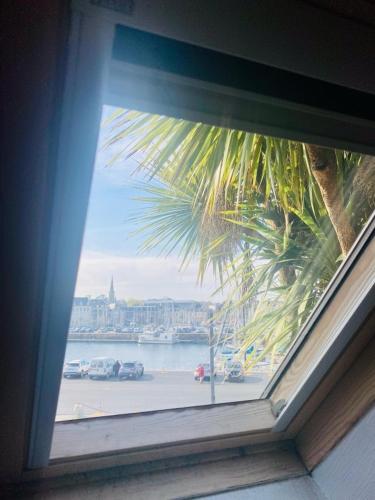 a window with a view of a view of a city at La maison du port in Paimpol