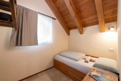 a small bedroom with a bed and a window at Baita Heidi - Villaggio dei Crodini in Crodo