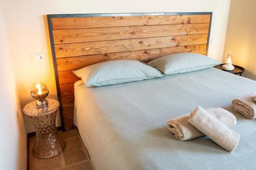 a bedroom with a large bed with a wooden headboard at Baita Heidi - Villaggio dei Crodini in Crodo