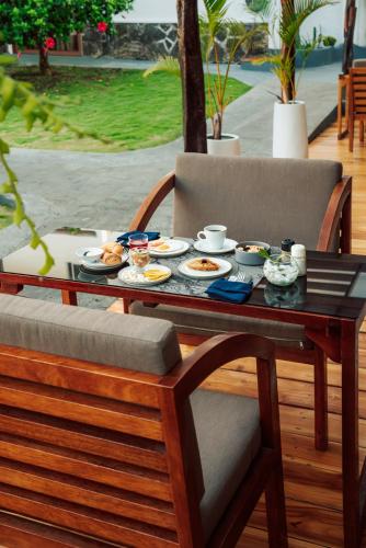 a wooden table with plates of food on it at Hotel Ninfa in Puerto Ayora
