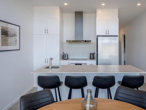 cocina con mesa, sillas y barra en Cove Landing Marina Apartment 3 YC Lily May, en Penneshaw