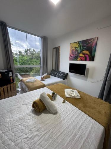 a hotel room with two beds and a large window at Pousada Hércules Beach Paradise in Maragogi