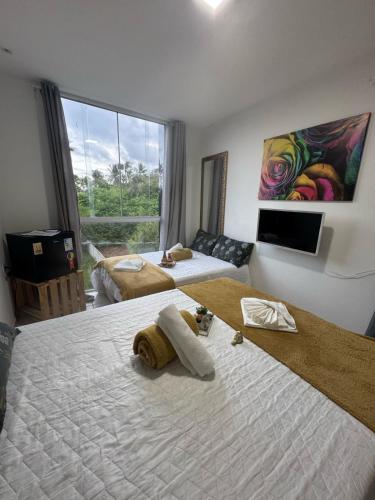 a hotel room with two beds and a large window at Pousada Hércules Beach Paradise in Maragogi