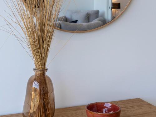 a vase sitting on a table in front of a mirror at Cove Landing Marina Apartment 2 SS James Comrie Sleeps 4 in Penneshaw