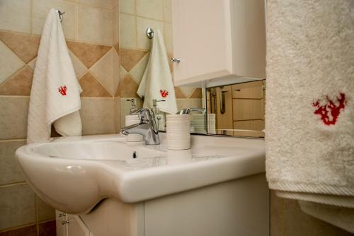 een badkamer met een witte wastafel en een spiegel bij Korallis Villas in Karavádhos