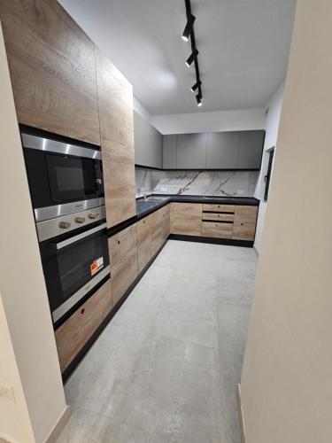 a kitchen with stainless steel appliances and wooden cabinets at Apartment with pool in St. Paul's Bay
