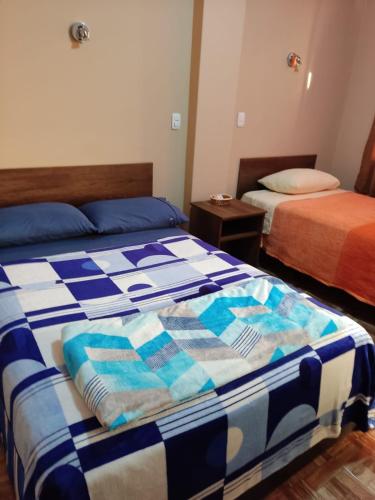 a bedroom with two beds with a quilt on them at D' Barrig in Trujillo