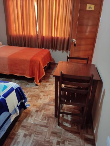 a bedroom with two beds and a table and chair at D' Barrig in Trujillo