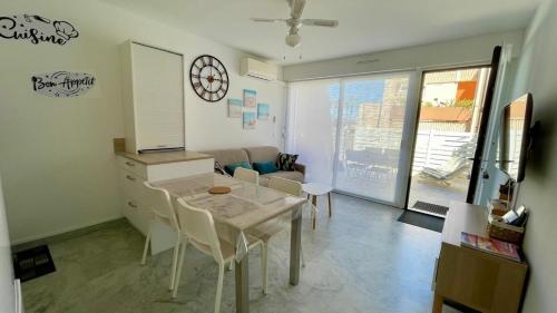 une cuisine et une salle à manger avec une table et des chaises dans l'établissement Appartement Terrasse, centre-ville, 5 min de la plage, à Cavalaire-sur-Mer