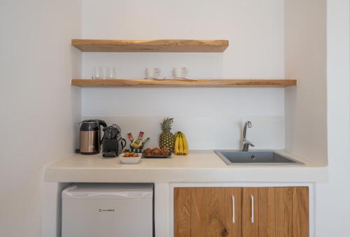 a white kitchen with a sink and a dishwasher at Kastraki Riviera in Kastraki Naxou