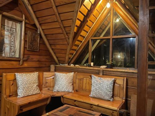 a room with benches in a cabin with windows at The Lake Frost in Nuwara Eliya
