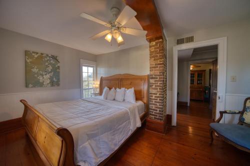 a bedroom with a bed with a ceiling fan at Downtown Secret Garden Piedmont in Eureka Springs