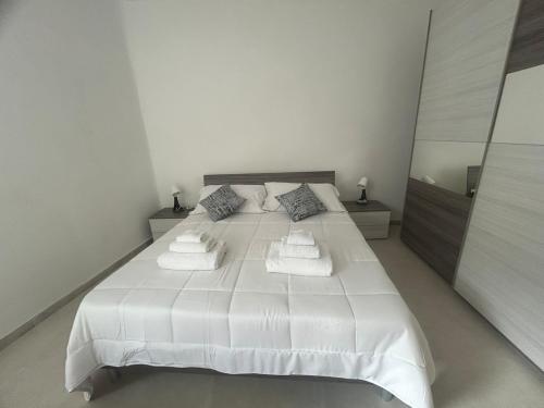 a white bedroom with a large white bed with pillows at Carradori 2 Apartment-Historic Center-Autodromo in Imola