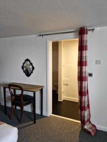 a room with a table and a chair and a door at The Cridford Inn in Trusham